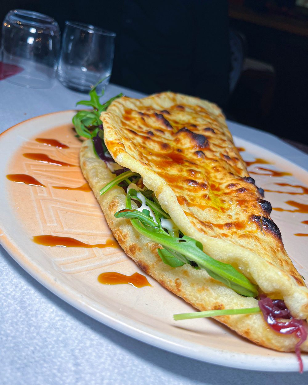 Calzone aperto Fusion con rucola, stracciatella e teriyaki