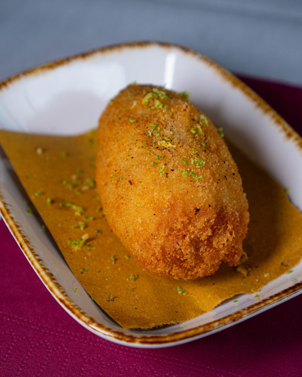 Supplì Cacio, Pepe e Lime impiattato con salsa